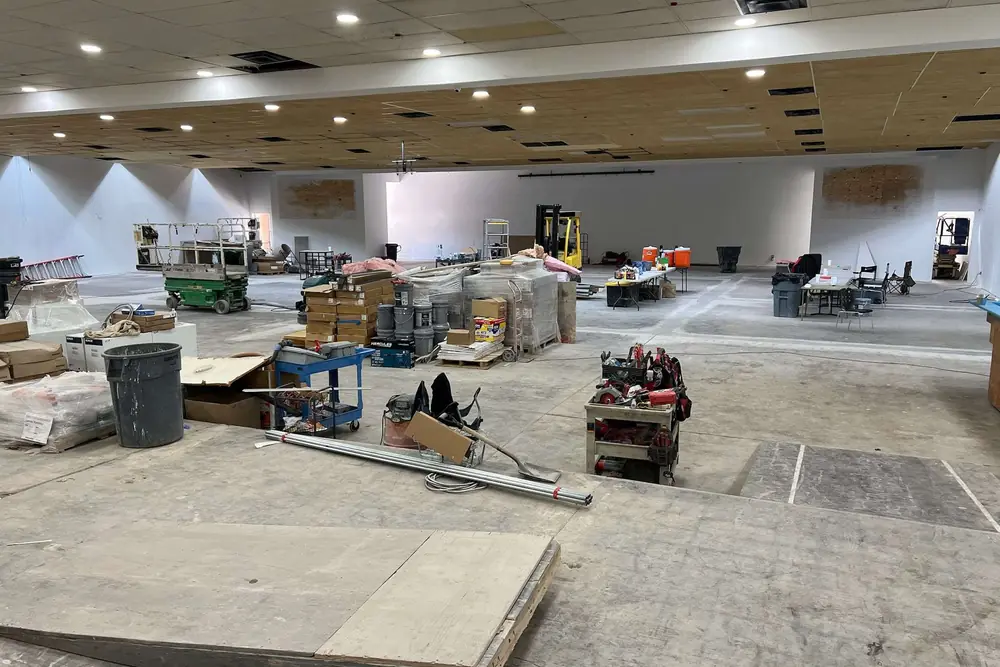 A large commercial interior under construction with flooring going in