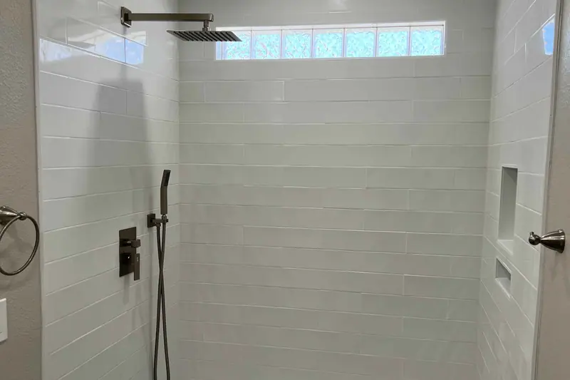 Walk-in shower finished in large format white tile