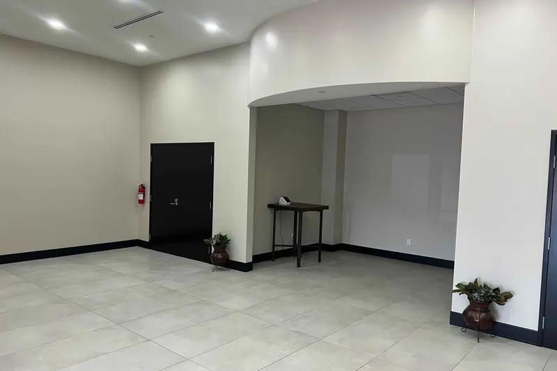 Commercial interior with a wide arched opening between two finished rooms
