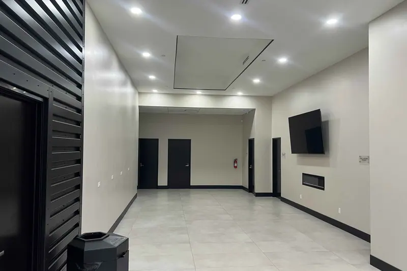 Commercial corridor with a black slat feature wall and recessed lighting