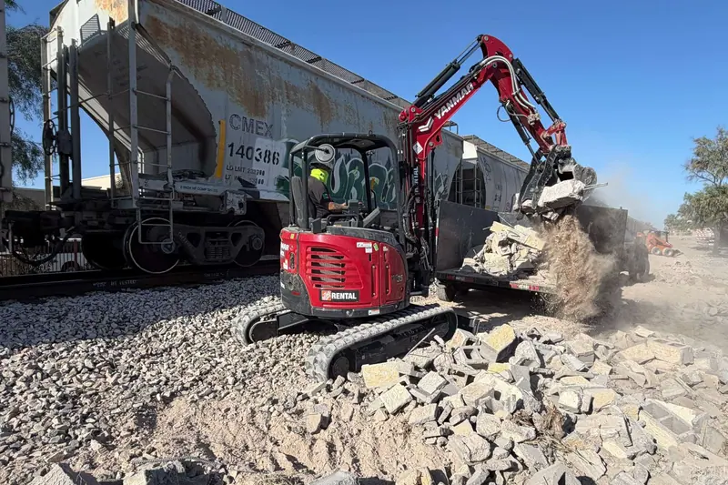 Excavator loading broken concrete during site demolition