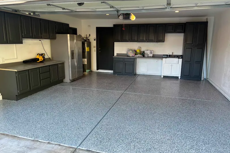 Garage with an epoxy flake floor and dark built-in cabinetry