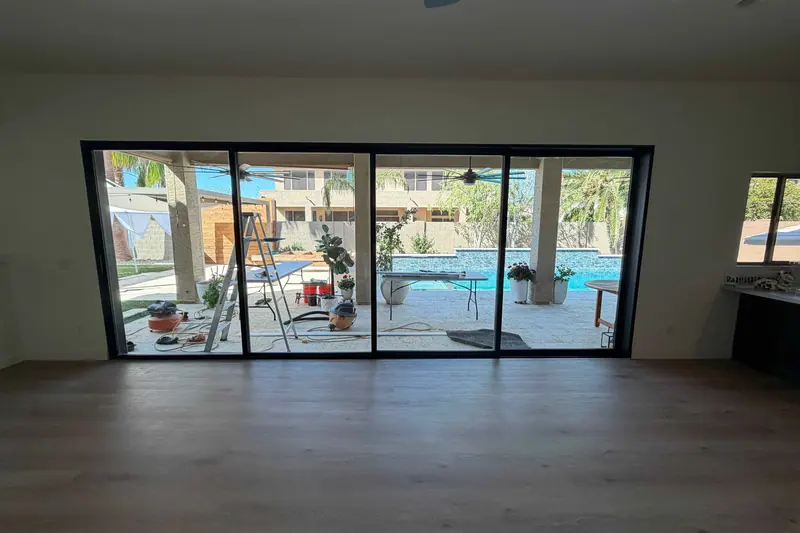 Multi-panel sliding glass wall opening a room onto a pool deck