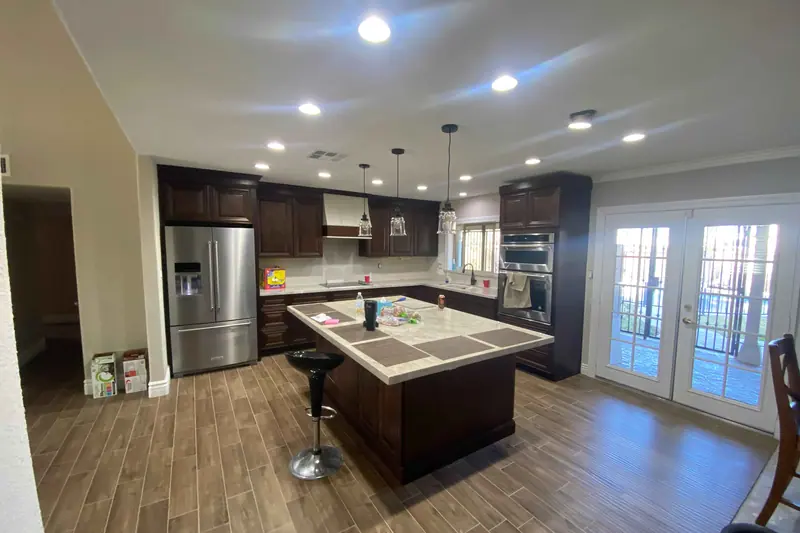 Open plan kitchen with dark cabinetry and a tiled island
