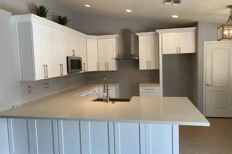 Finished white kitchen with a peninsula and quartz countertops