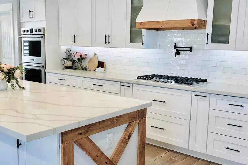 White kitchen with a wood island featuring an X detail and a timber shelf
