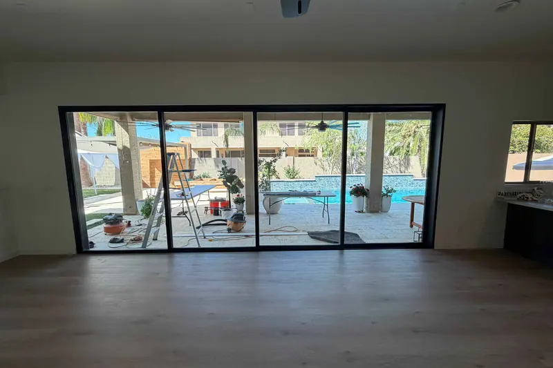 Finished room with new flooring and a glass slider looking out to a pool