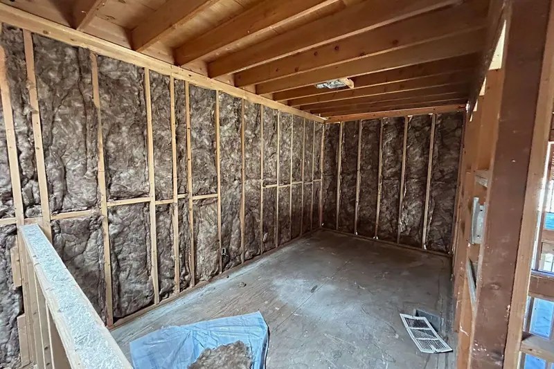 New framing and insulation in place in a room being rebuilt from the studs