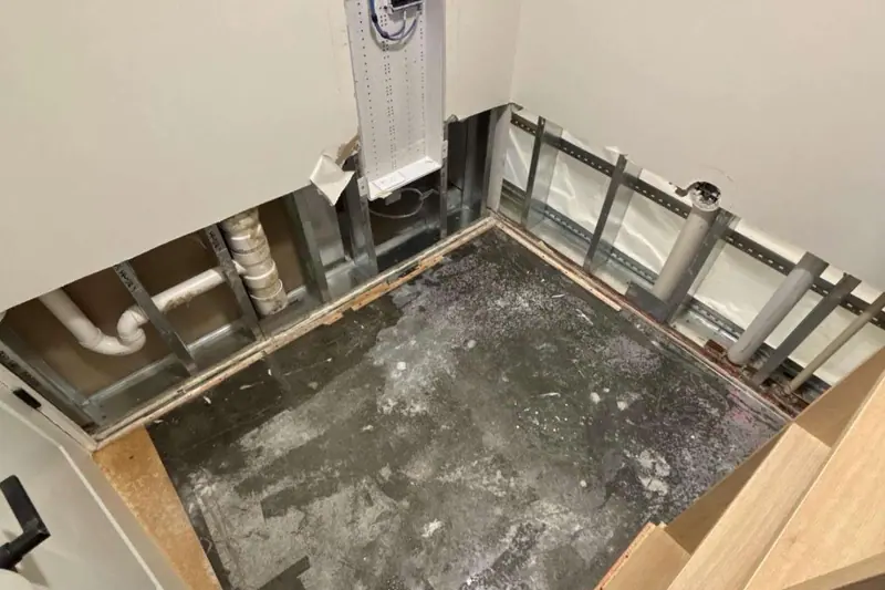 Cabinets and flooring removed around a wet subfloor so the structure can dry