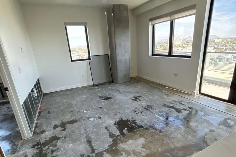 Open room with the flooring lifted and staining visible across the wet slab